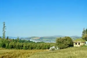 Ty mam mawr off grid eco retreat centre roundhouse and big yurt view west to snowdonia in summer