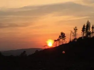 Fiery sunset off grid sustainable eco glampsite and glamping