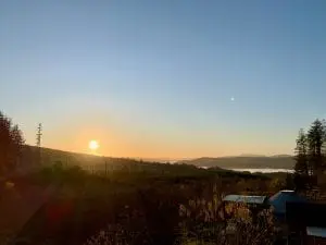 Sunset over the small yurt from the roundhouse roof off grid sustainable eco glampsite and glamping