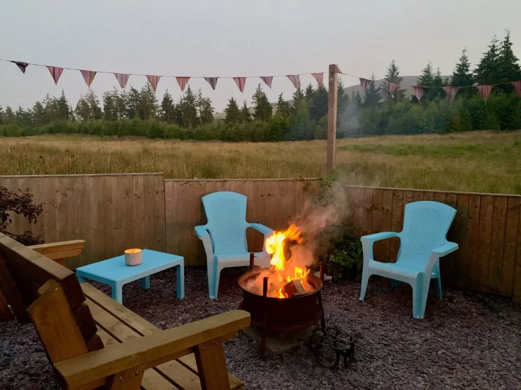 Ty crwn mawr yurt outside covered dining area and firepit nighttime and evening 1 off grid sustainable eco glampsite and glamping