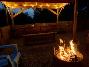 Ty crwn mawr yurt outside covered dining area and firepit nighttime and evening 12 off grid sustainable eco glampsite and glamping