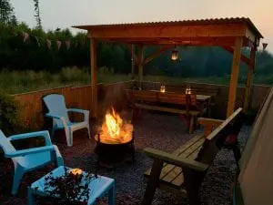 Ty crwn mawr yurt outside covered dining area and firepit nighttime and evening 3 off grid sustainable eco glampsite and glamping