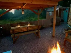 Ty crwn mawr yurt outside covered dining area and firepit nighttime and evening 4 off grid sustainable eco glampsite and glamping