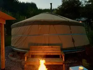Ty crwn mawr yurt outside covered dining area and firepit nighttime and evening 5 off grid sustainable eco glampsite and glamping