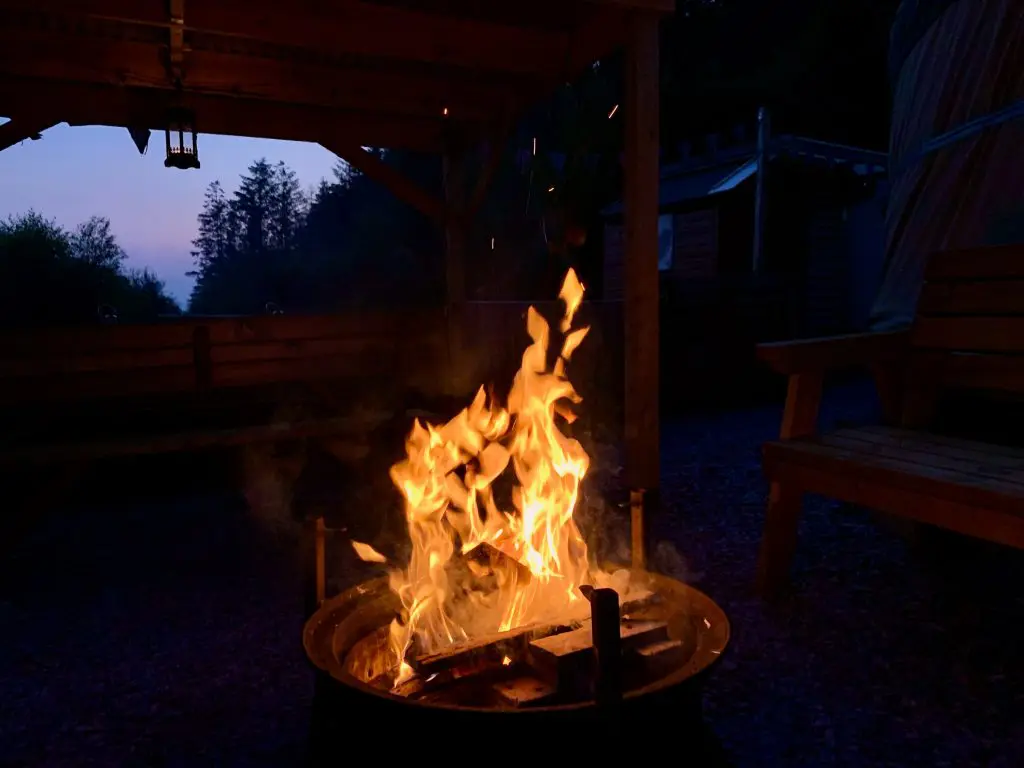 Ty crwn mawr yurt outside covered dining area and firepit nighttime and evening 6 off grid sustainable eco glampsite and glamping