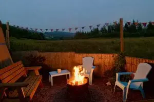 Ty crwn mawr yurt outside covered dining area and firepit nighttime and evening 7 off grid sustainable eco glampsite and glamping