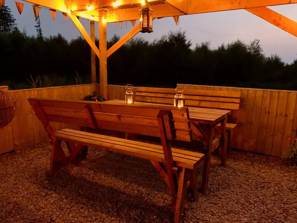 Ty crwn mawr yurt outside covered dining area and firepit nighttime and evening 9 off grid sustainable eco glampsite and glamping