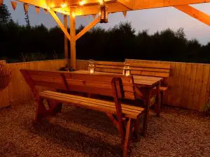 Ty crwn mawr yurt outside covered dining area and firepit nighttime and evening 9 off grid sustainable eco glampsite and glamping