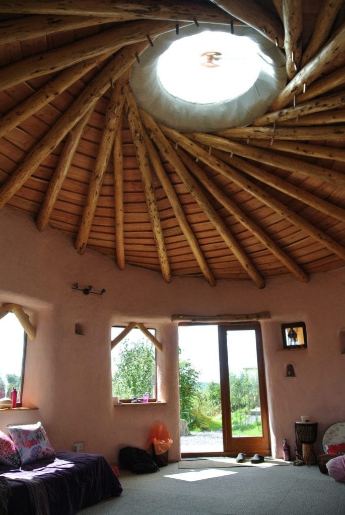 Inside the straw bale roundhouse looking west with a great view of the vortex like reciprocating frame roof and skylight