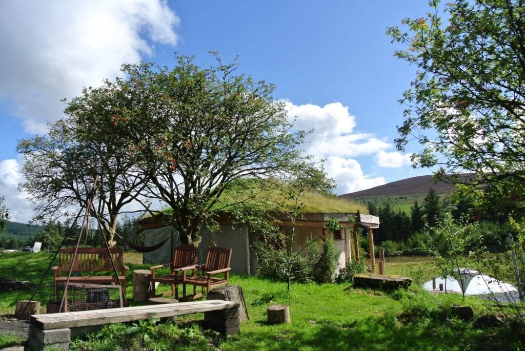 The straw bale roundhouse and central fire pit at Ty Mam Mawr off grid eco retreat centre