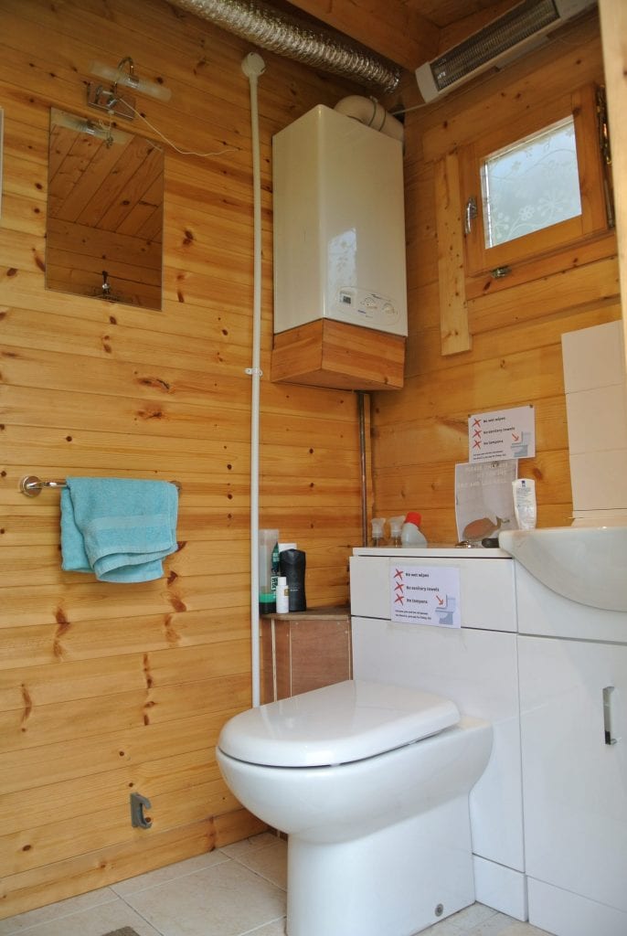 Log cabin bathroom flushing loo and sink off grid sustainable eco glampsite and glamping