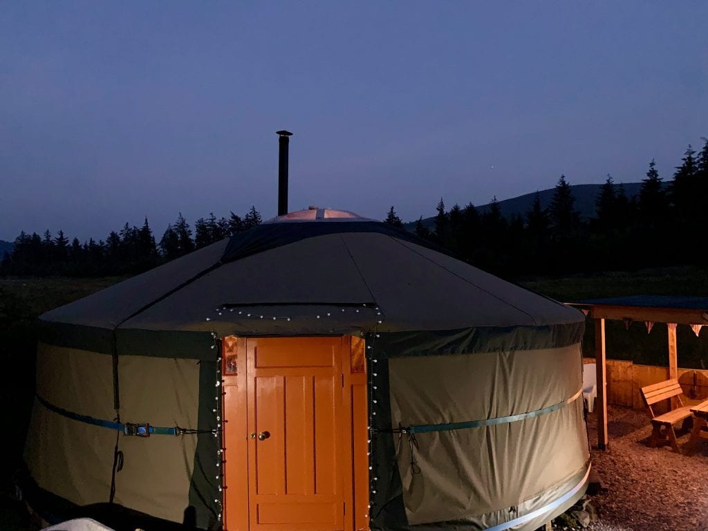 Ty crwn mawr yurt outside covered dining area and firepit nighttime and evening 15 off grid sustainable eco glampsite and glamping